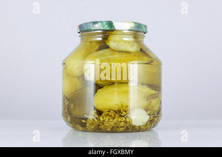 Saure Gurken im Glas auf dem grauen Hintergrund isoliert Stockfoto