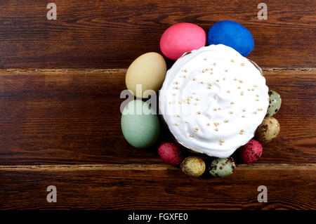 Osterkuchen mit verschiedenen Eiern herum über hölzerne Hintergrund von oben Stockfoto
