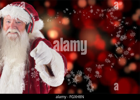 Zusammengesetztes Bild von Santa ist etwas Musik hören. Stockfoto