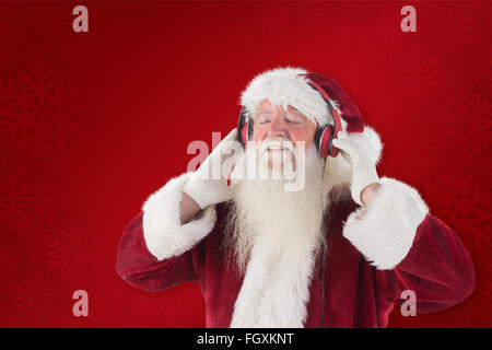 Zusammengesetztes Bild des Weihnachtsmannes genießt einige Musik Stockfoto