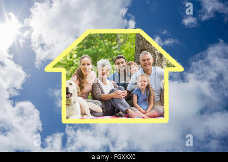Zusammengesetztes Bild der Großfamilie mit ihrem Hund im Park sitzend Stockfoto