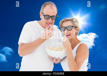 Montagebild von älteres paar 3d Brille Essen popcorn Stockfoto