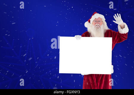 Zusammengesetztes Bild von Santa hält ein Schild und winkt Stockfoto