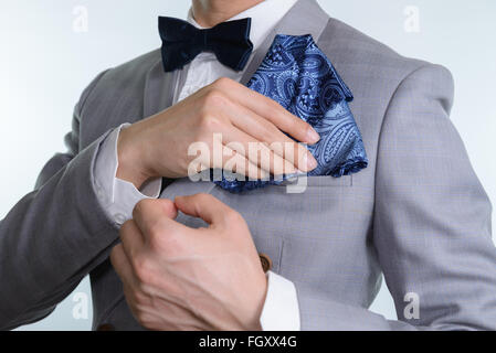 Mann im grauen Anzug, karierten Textur, blaue Fliege und Einstecktuch, weißen Hintergrund hautnah Stockfoto