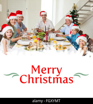Zusammengesetztes Bild von happy Family im Santa Hüte mit Weihnachtsessen Stockfoto