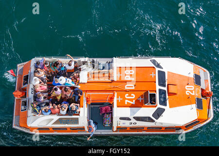 Touristen an Bord eines Lebens Boot zart Rückkehr zu ihrem Kreuzfahrtschiff Stockfoto