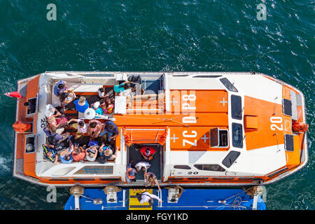 Touristen an Bord eines Lebens Boot zart Rückkehr zu ihrem Kreuzfahrtschiff Stockfoto