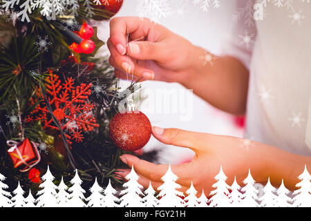 Zusammengesetztes Bild der Frau Weihnachtsschmuck am Baum hängen Stockfoto