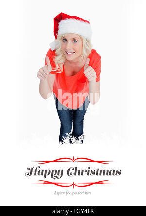 Zusammengesetztes Bild blonder Frau ihre Daumen aufstellen, während des Tragens Weihnachten Kleidung Stockfoto
