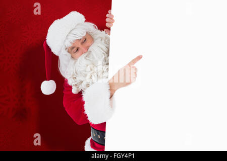 Zusammengesetztes Bild des festlichen Weihnachtsmann präsentiert Zeichen Stockfoto