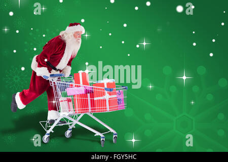 Zusammengesetztes Bild von Santa schiebt einen Einkaufswagen Stockfoto