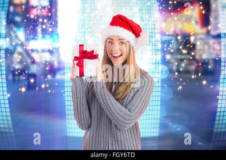 Zusammengesetztes Bild der festlichen Blondine hält Weihnachtsgeschenk Stockfoto