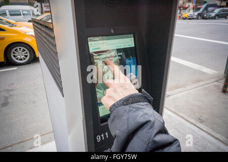 Eine Frau benutzt einen LinkNYC Kiosk für den Internetzugang in New York auf Samstag, 20. Februar 2016. Mehr als 7500 Kioske sind zu installierten ersetzen Stand allein Münztelefon Kioske bieten kostenfreies WLAN, Internet-Zugang über einen Touch-Screen, Telefon geladen und kostenlos telefonieren. Das System soll durch Werbung auf den Seiten der Kioske unterstützt werden. (© Richard B. Levine) Stockfoto