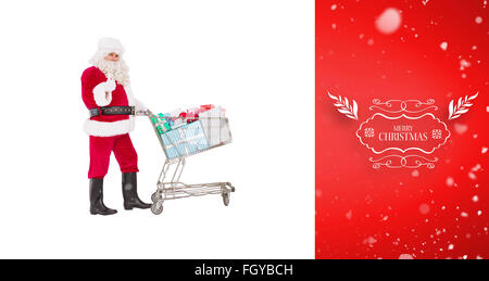 Zusammengesetztes Bild des positiven Santa, die Geschenke mit einem Trolley zu liefern Stockfoto