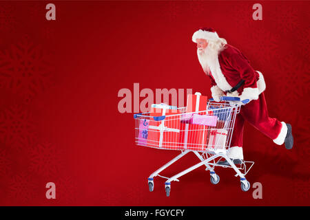 Zusammengesetztes Bild von Santa schiebt einen Einkaufswagen Stockfoto