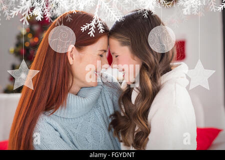 Zusammengesetztes Bild von festlichen Mutter und Tochter auf der couch Stockfoto