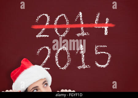 Zusammengesetztes Bild der hübsche Brünette in Nikolausmütze zeigt weißes Plakat Stockfoto