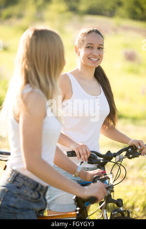 Zwei junge schöne fröhliche Frauen Freundinnen tragen Jeans Shorts auf Fahrräder im Park am sonnigen Sommertag, gute Zeit Stockfoto