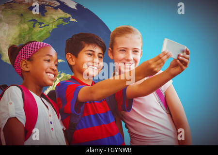 Zusammengesetztes Bild der glückliche Kinder nehmen Selfie im Flur der Schule Stockfoto