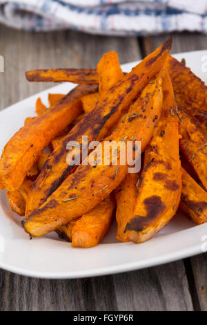 Süßkartoffel Pommes frites Keile Closeup auf Holztisch Stockfoto