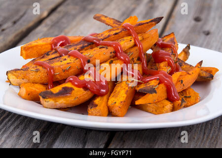 Süßkartoffel Pommes frites Keile Closeup auf Holztisch mit ketchup Stockfoto