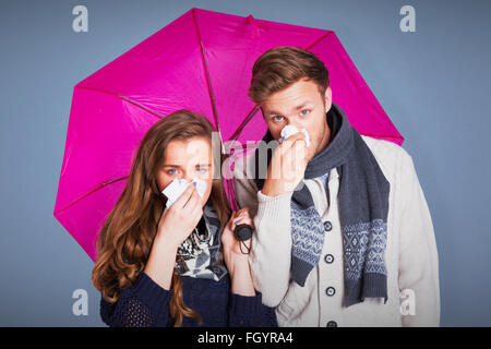 Zusammengesetztes Bild des Paares, die Nase weht, Regenschirm mit gedrückter Stockfoto