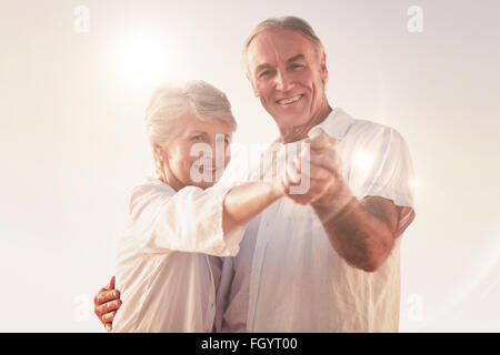 Montagebild von älteres paar tanzen am Strand Stockfoto