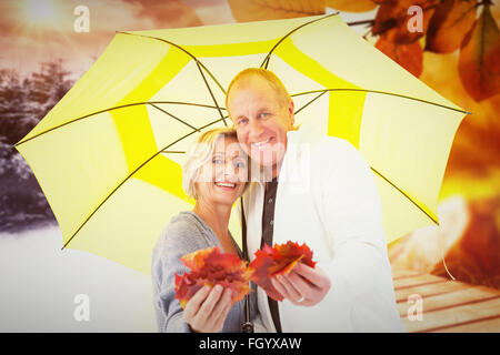Zusammengesetztes Bild von glücklichen Reife paar zeigt Herbst Blätter unter Dach Stockfoto