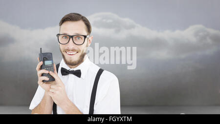 Zusammengesetztes Bild geeky Hipster hält ein Retro-Handy Stockfoto