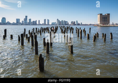 Blick auf Jersey City (Newport / Hoboken) Skyline mit hölzernen Stapel Bereich im Vordergrund. Stockfoto