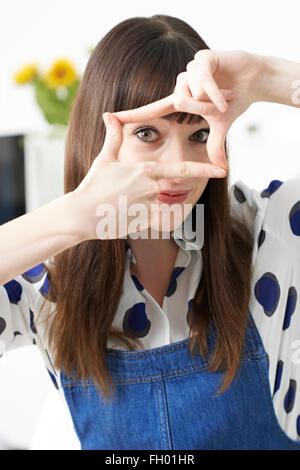 Porträt der jungen Frau macht Finger-Frame Stockfoto