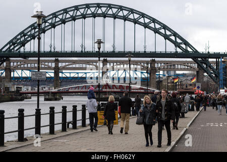Sonntagmorgen Shopper spazieren Newcastle Quayside mit Fluss-Brücken der Stadt im Hintergrund Stockfoto
