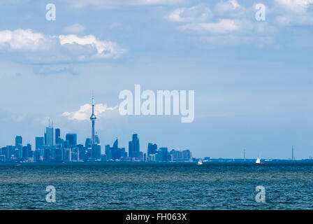 Toronto Skyline der Stadt in blau getönt, über wellige Wasser gegen bewölkter Himmel. einige Boote segeln auf See vor der Stadt. Stockfoto