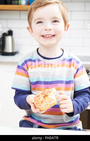 Kleiner Junge zuckerhaltige Donut für Snack Essen Stockfoto