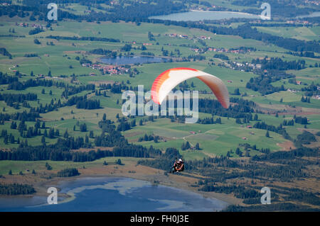 Füssen, Deutschland - 11. September 2010: weiß-Orange Gleitschirm fliegen über den Foggenlake Stockfoto