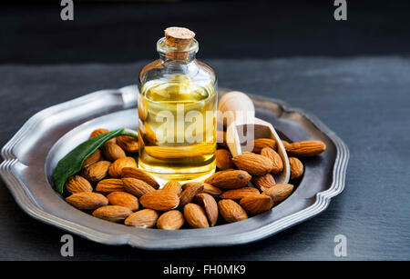 Mandelöl in durchsichtige Flasche mit Mandeln, gesunde Nüssen Öl Stockfoto