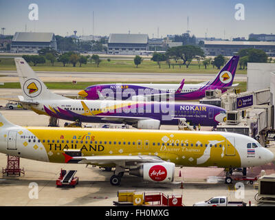 Bangkok, Thailand. 23. Februar 2016. Air Asia Airbus vor Nok Air Flugzeug auf eine Schürze am Flughafen Bangkok-Don Mueang. NOK Air, teilweise im Besitz von Thai Airways International und einer der größten und erfolgreichsten Billigfluglinien in Thailand, 20 Flüge Dienstag wegen einem Mangel an Piloten gestrichen und kündigte an, dass andere Flüge abgesagt oder über das Wochenende gesperrt werden würde. Die Stornierungen kam nach ein wilden Streik von mehreren Piloten Sonntagabend Flüge annullierte und Reisende mehr als tausend gestrandete. Der pilot Mangel bei Nok kommt zu einem Zeitpunkt als die Thai Aviat Stockfoto