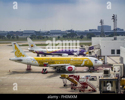 Bangkok, Thailand. 23. Februar 2016. Air Asia Airbus vor Nok Air Flugzeug auf eine Schürze am Flughafen Bangkok-Don Mueang. NOK Air, teilweise im Besitz von Thai Airways International und einer der größten und erfolgreichsten Billigfluglinien in Thailand, 20 Flüge Dienstag wegen einem Mangel an Piloten gestrichen und kündigte an, dass andere Flüge abgesagt oder über das Wochenende gesperrt werden würde. Die Stornierungen kam nach ein wilden Streik von mehreren Piloten Sonntagabend Flüge annullierte und Reisende mehr als tausend gestrandete. Der pilot Mangel bei Nok kommt zu einem Zeitpunkt als die Thai Aviat Stockfoto