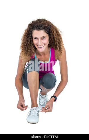 Porträt der glückliche junge Frau, die Schnürsenkel zu binden Stockfoto