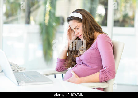 Unglücklich schwangere Frau mit Kopfschmerzen Stockfoto