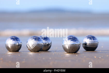 Eine Reihe von Stahl Petanque Kugeln an einem Sandstrand. Stockfoto