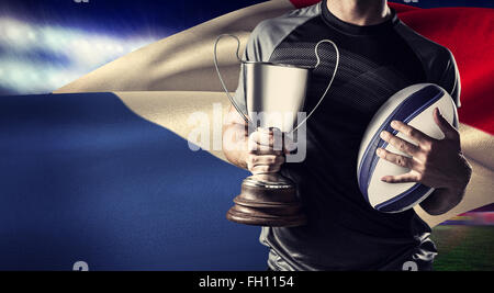 Zusammengesetztes Bild des Mittelteils des erfolgreicher Rugbyspieler holding, Pokal und ball Stockfoto