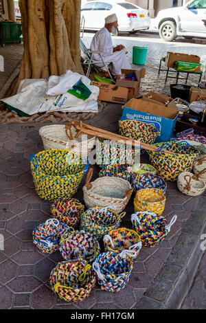 Ein älterer Mann verkaufen bunte Körbe In der Straße, Nizwa Souk, Nizwa, Ad Dakhiliyah Region, Oman Stockfoto