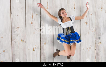 Zusammengesetztes Bild von hübschen Oktoberfest Mädchen lächelnd und springen Stockfoto