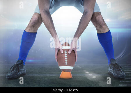 Zusammengesetztes Bild des american-Football-Spieler kann Ball zwischen die Beine Stockfoto