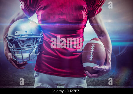 Zusammengesetztes Bild des Mittelteils des american Footballspieler mit Helm und ball Stockfoto