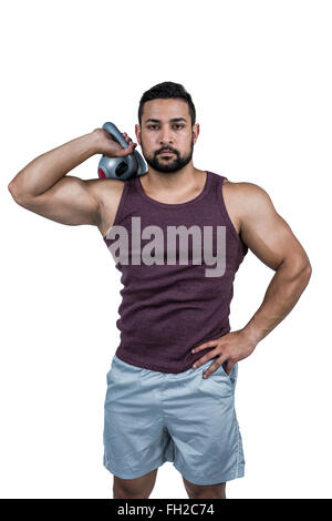 Muskuläre ernster Mann hält eine kettlebell Stockfoto