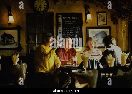 Eine Gruppe von Erwachsenen sitzen in einem Pub genießen Sie einen Drink und einen Chat. Kent. England. UK Stockfoto