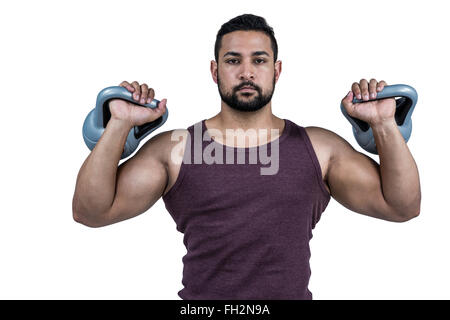 Muskuläre ernster Mann heben kettlebells Stockfoto