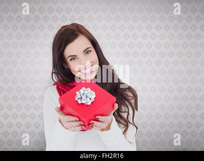 Zusammengesetztes Bild glücklich Brünette zeigt rot Geschenk mit Schleife Stockfoto